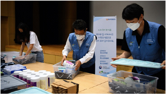 한성희(왼쪽 두번째) 포스코건설 한성희 사장이 27일 임직원들과 함께 6.25 참전 유공자를 위한 폭염 피해방지 키트를 제작하고 있다. <포스코건설 제공>